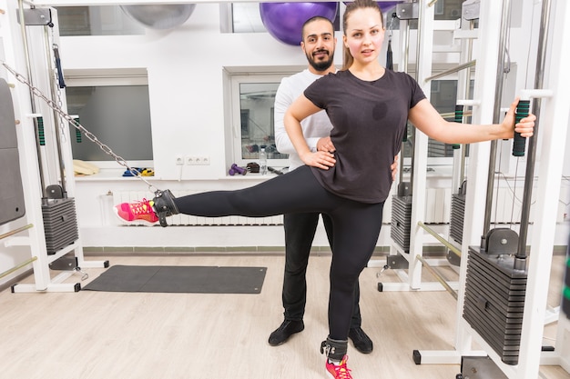 Jeune femme exerçant les jambes avec un entraîneur personnel