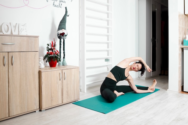 Jeune femme exerçant le yoga dans son propre appartement et profiter de sa journée