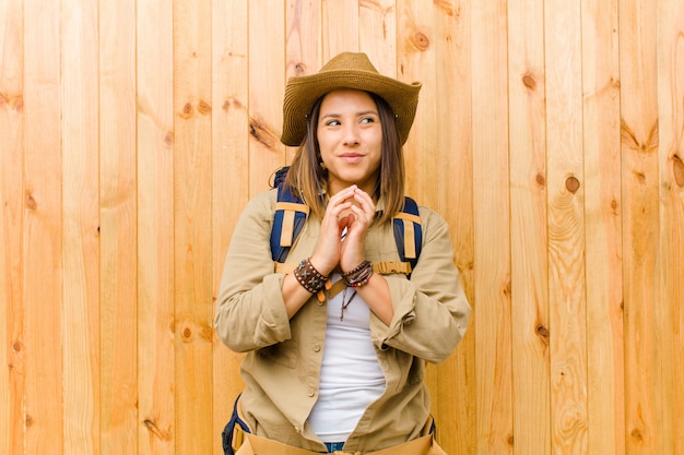 Jeune femme exploratrice latine sur mur en bois