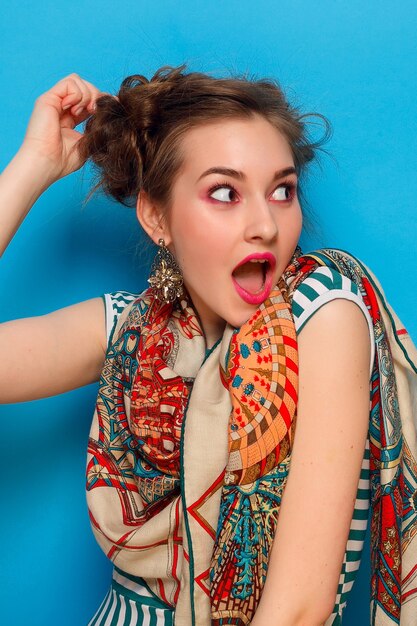 Jeune femme avec une expression faciale choquée sur fond bleu