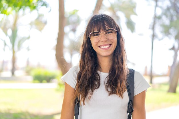 Jeune femme à l'extérieur avec une expression heureuse