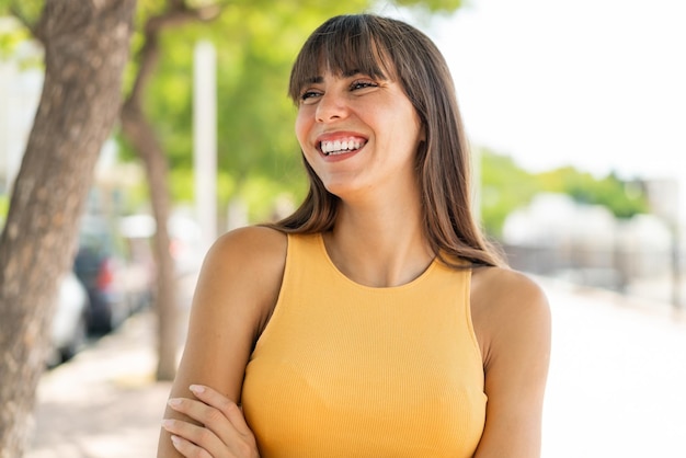 Jeune femme à l'extérieur heureuse et souriante