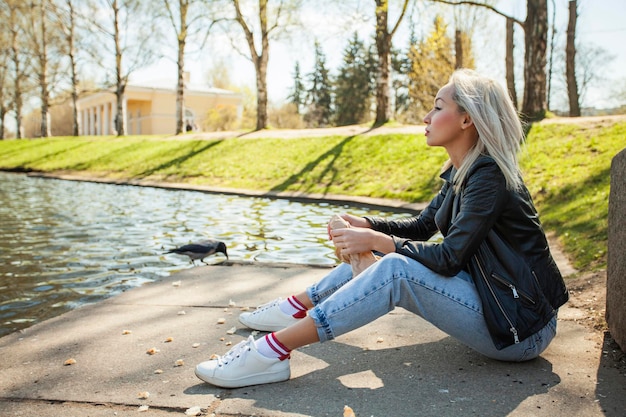 Jeune femme à l'extérieur Modèle blonde en denim bleu et cuir noir