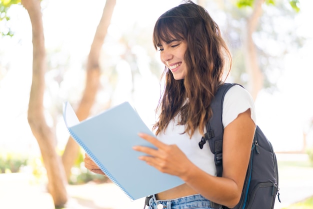 Jeune femme à l'extérieur tenant un carnet