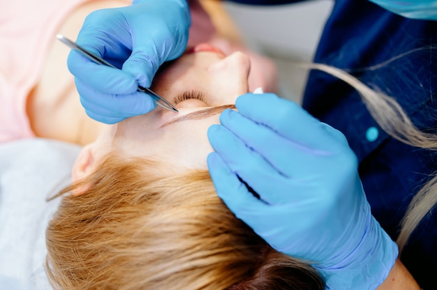 Jeune femme façonne ses sourcils avec un crayon à sourcils