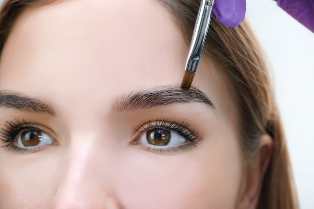 Jeune femme façonner les sourcils avec une brosse, Close up