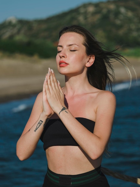 jeune femme, faire du yoga sur la plage