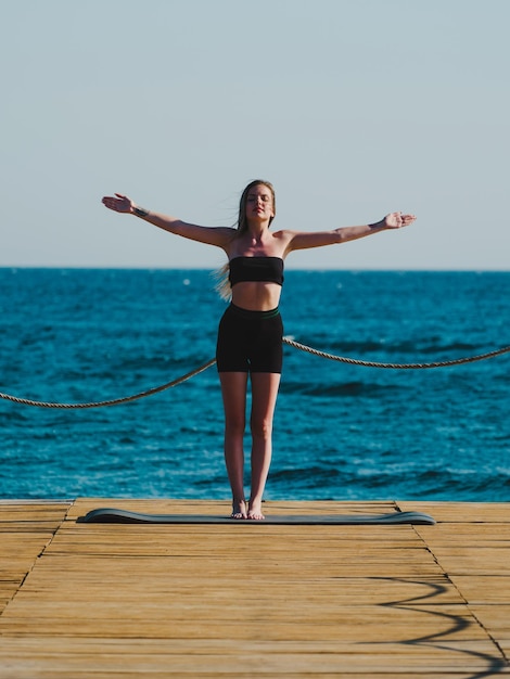 jeune femme, faire du yoga sur la plage