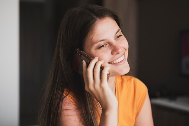 Une jeune femme faisant un appel téléphonique à la maison
