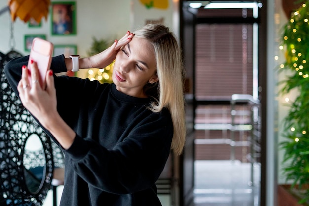 Une jeune femme faisant un autoportrait pour télécharger une photo sur un réseau social