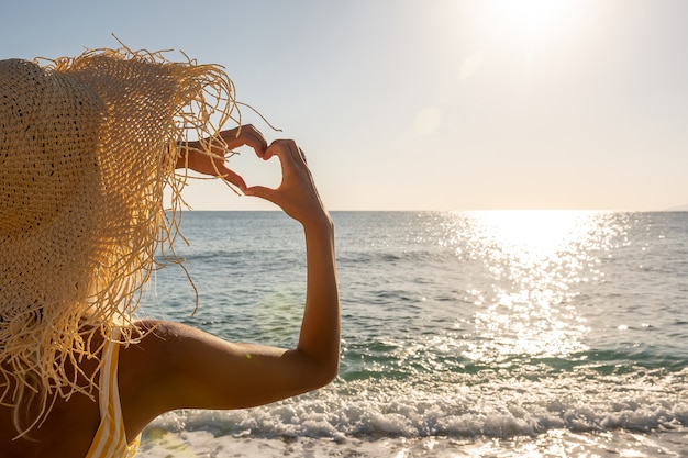 Photo jeune femme faisant un coeur avec ses mains