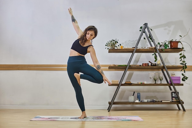 Jeune femme faisant du fitness à la maison La fille fait du sport sur un tapis Femme faisant du yoga