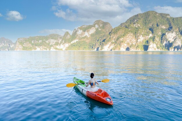 Photo jeune femme faisant du kayak parmi la mer et les montagnes lors d'un voyage en thaïlande. incroyable thailande