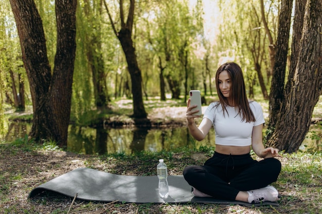 Jeune femme faisant du sport et écoutant de la musique dans le parc