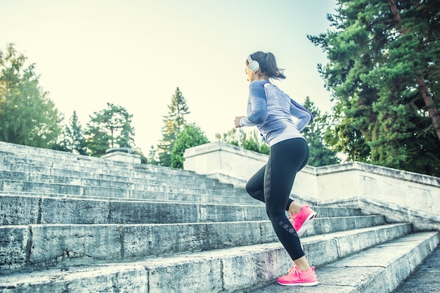 Jeune femme faisant du sport et montant les escaliers.