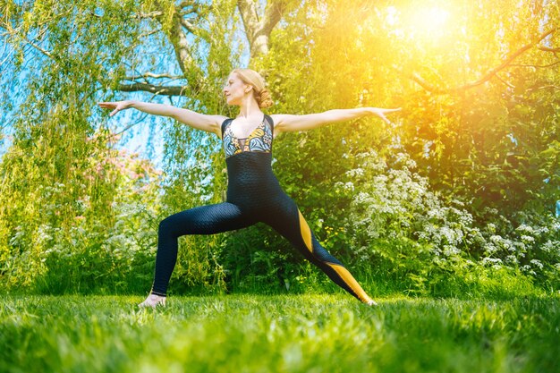 Jeune femme faisant du yoga asana dans park girl stretching exercice en position de yoga femme en bonne santé heureuse