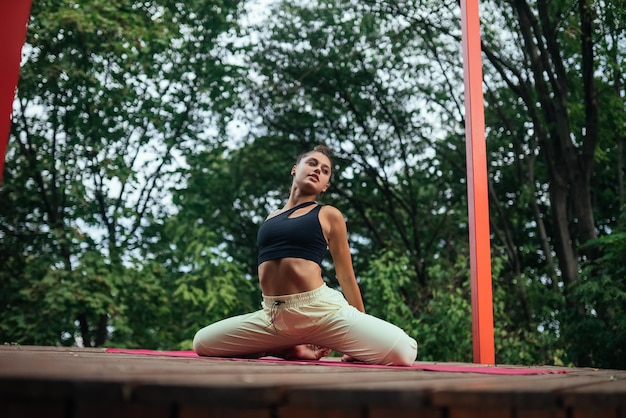 Une jeune femme faisant du yoga dans la cour