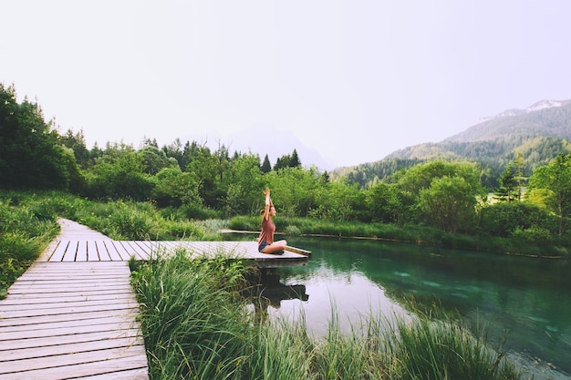 Jeune femme faisant du yoga et méditant en position du lotus sur fond de nature