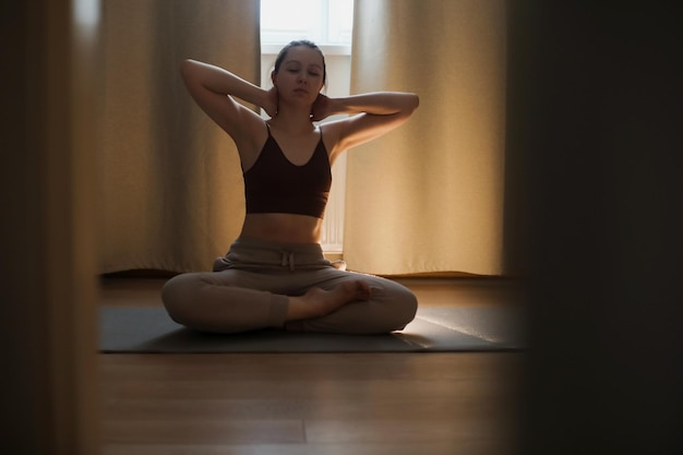 Jeune femme faisant du yoga et pratiquant la méditation à la maison concept de méditation et de santé mentale