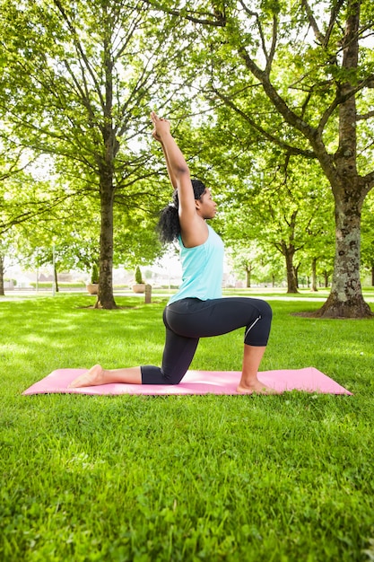 Jeune femme faisant du yoga sur le tapis