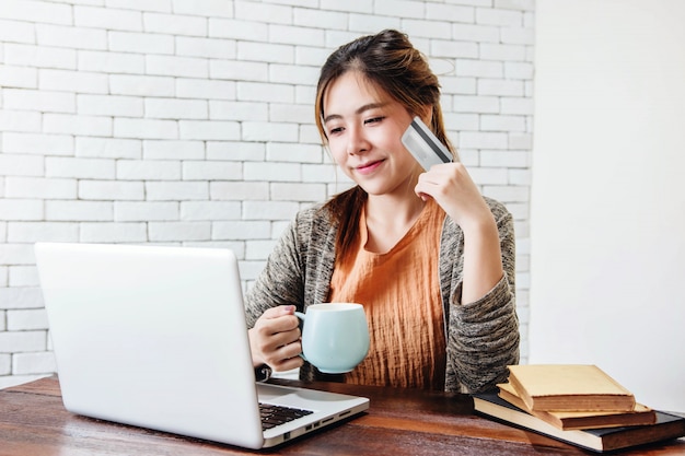 Jeune Femme Faisant Des Emplettes Ou Effectuant Des Paiements Par Carte De Crédit