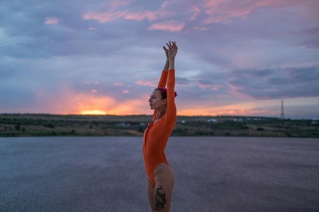 Une jeune femme faisant de l'exercice au coucher du soleil.