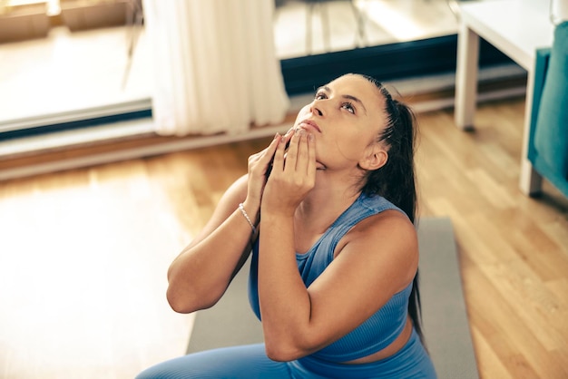 Jeune femme faisant de l'exercice à la maison le matin. Elle fait de l'exercice d'étirement.