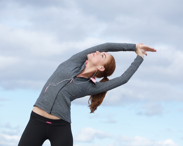 Jeune femme faisant des exercices d&#39;étirement en plein air