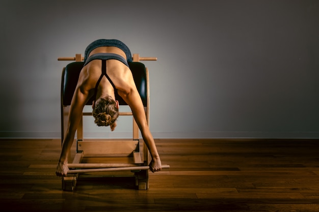 Jeune femme faisant des exercices de pilates avec un lit réformateur