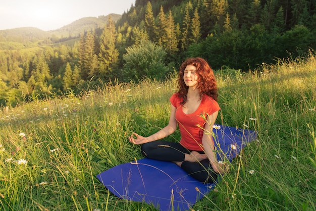 Jeune femme faisant des exercices de yoga dans la nature