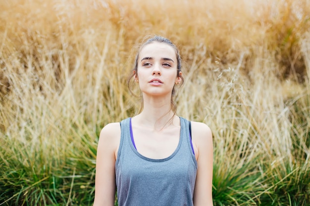 Jeune femme faisant des exercices de yoga dans un parc verdoyant