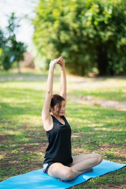 Jeune femme faisant des exercices de yoga en plein air dans le parc, concept de yoga sport