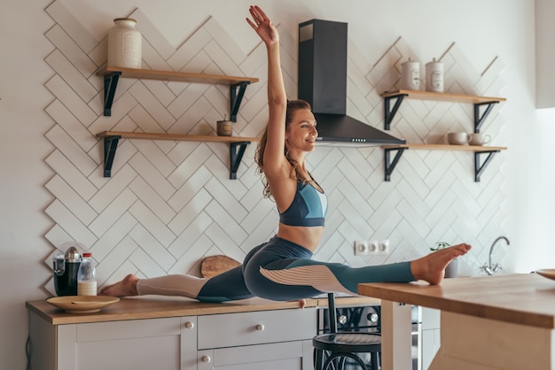 Jeune femme faisant le grand écart, fait preuve d'une excellente flexibilité.