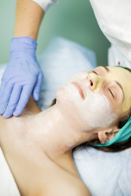 Jeune femme faisant un masque facial et relaxant