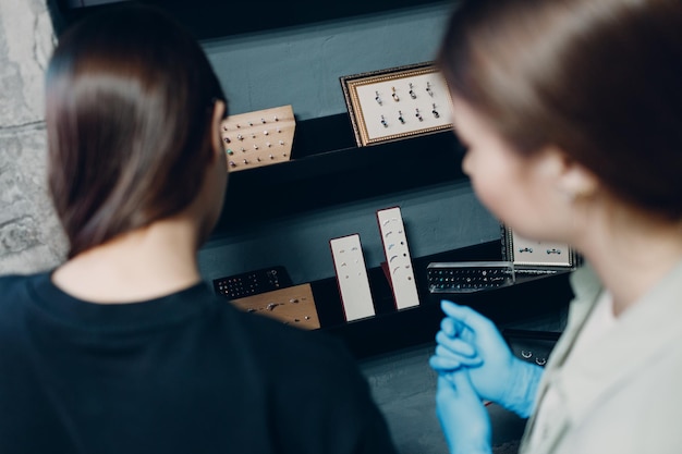 Jeune femme faisant le perçage des oreilles au salon de beauté