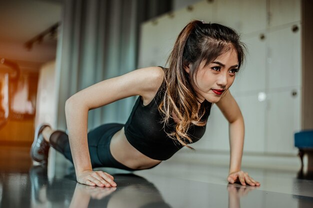 Jeune femme faisant des pompes à la salle de gym