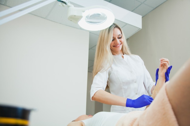 Jeune femme faisant la procédure d'épilation au sucre au salon de beauté