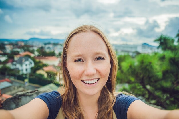 Jeune femme faisant selfie sur le fond de la ville de Dalat