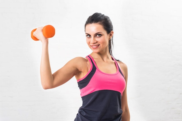 Jeune femme fait du fitness sportif avec des haltères Mode de vie sain Santé secoue les muscles de la main haltères