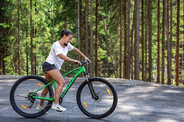 Une jeune femme fait du vélo dans une région montagneuse de la forêt