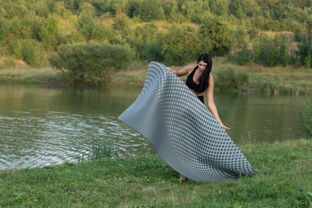 Jeune femme fait du yoga près du lac Détendez-vous la méditation des sports de plein air Bien-être remise en forme d'été