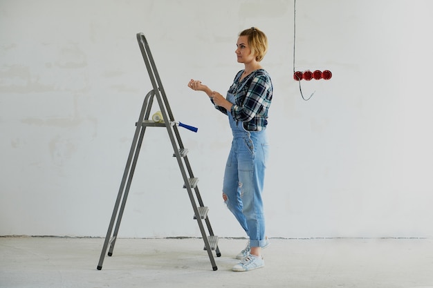 Jeune femme fait des réparations dans sa maison