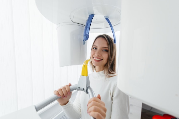 Une jeune femme fait un scanner de la mâchoire un instantané circulaire de la mâchoire dans la dentisterie moderne Traitement des prothèses dentaires et blanchiment des dents Scanner panoramique de radiologie