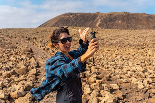 Une jeune femme fait une vidéo à côté du cratère du volcan Calderon Hondo près de Corralejo, sur la côte nord de l'île de Fuerteventura, aux Canaries. Espagne