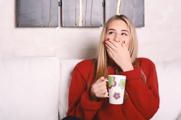 Jeune femme fatiguée avec une tasse de café.