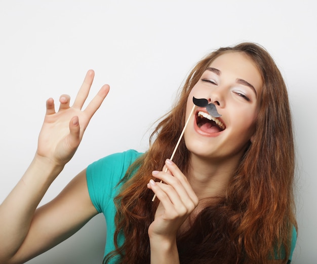 Jeune femme avec de fausses moustaches. Prêt pour la fête.