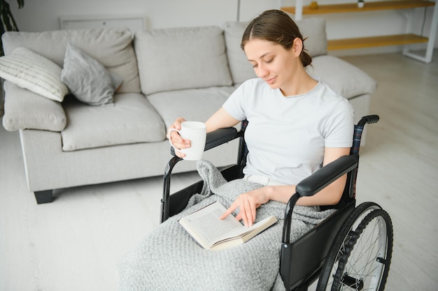 Jeune femme en fauteuil roulant à la maison