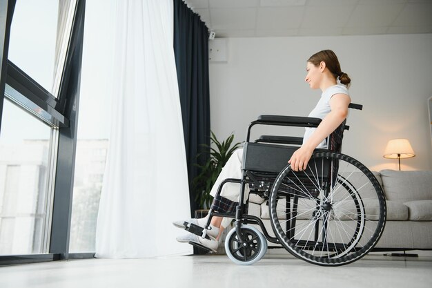 Jeune femme en fauteuil roulant à la maison