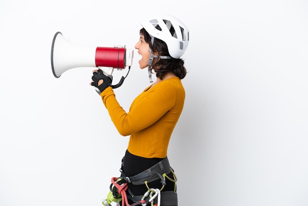 Jeune femme femme d'alpiniste isolée sur fond blanc criant à travers un mégaphone