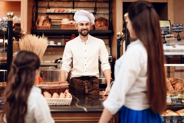 Jeune femme avec fille acheter du pain en boulangerie.